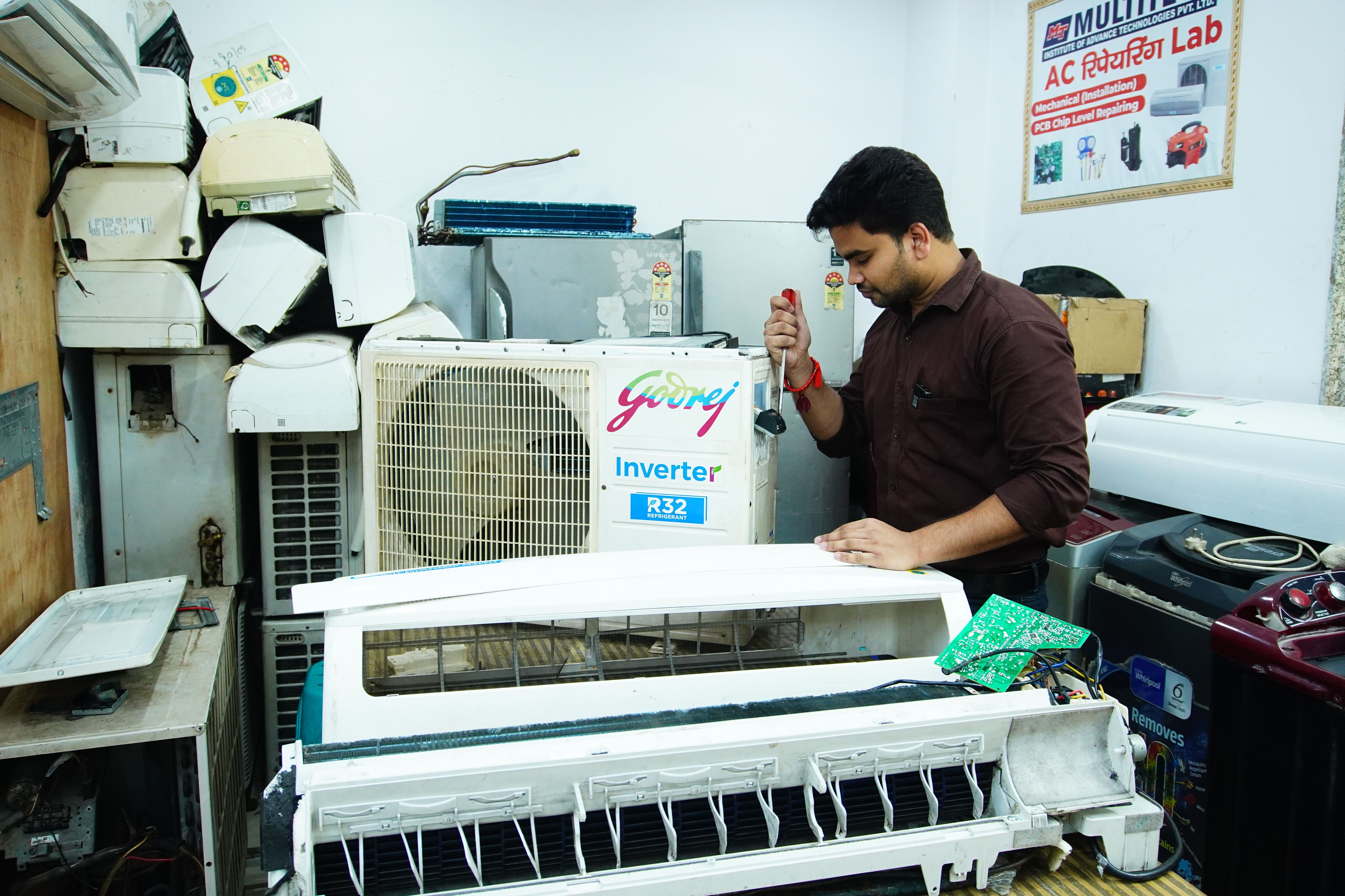 HVAC technician repairing an air conditioner in a workshop